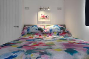 a bed with a colorful comforter in a bedroom at The Carriage in Fort William