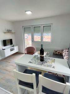 - un salon avec une table blanche et des verres à vin dans l'établissement Apartman Mila, à Višegrad