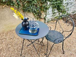 uma pequena mesa com um vaso e uma cadeira em Maison balnéo centre-ville @casaberruyere em Bourges