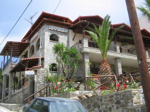 a house with a palm tree in front of it at ΠΑΝΣΙΟΝ ΑΓΓΕΛΟΣ ΜΑΝΑΡΗ in Ouranoupoli