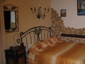 a bedroom with a bed and a stone wall at ΠΑΝΣΙΟΝ ΑΓΓΕΛΟΣ ΜΑΝΑΡΗ in Ouranoupoli