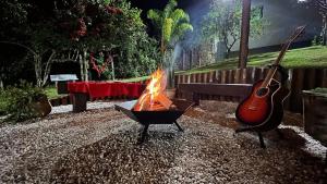uma fogueira com uma guitarra num quintal em Recanto Jade em Taubaté