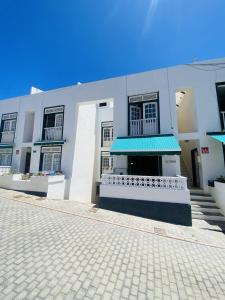 a white building with a blue awning on it at EL JORADO in Tamaduste