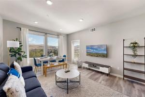 a living room with a blue couch and a table at Chic Apt w Jacuzzi, Pool, BBQ, & Mountain Views in Sparks
