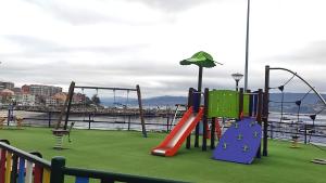 a playground with a slide and swings at Playa en las Rías Baixas - Raxó in Raxo