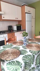 a kitchen with a table with a green and white table cloth at Playa en las Rías Baixas - Raxó in Raxo