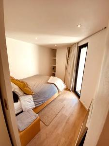 Habitación pequeña con cama y ventana en Appartement 1 chambre - LAKE SIDE HOUSE, en Rixensart