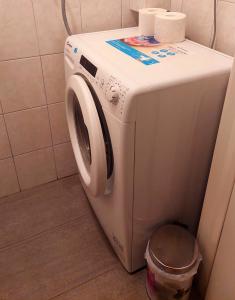 a washing machine in a bathroom with a trash can at Studio apartman Dolenac in Zagreb