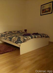 een bed in een slaapkamer met een houten vloer bij Studio apartman Dolenac in Zagreb