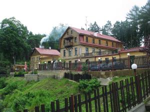 uma casa grande com uma cerca em frente em Hotel Garni Belveder em Hřensko