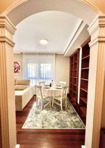 un soggiorno con tavolo e sedie bianchi di Apartamento Somocuevas a Liencres