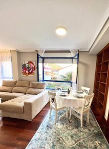 a living room with a couch and a table and chairs at Apartamento Somocuevas in Liencres