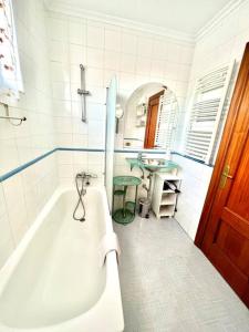 Baño blanco con bañera y lavamanos en Apartamento Somocuevas en Liencres