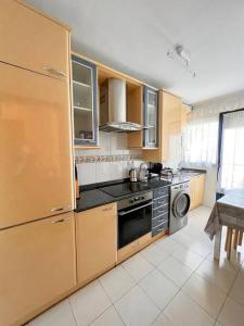 a kitchen with wooden cabinets and a stove top oven at Apartamento Somocuevas in Liencres