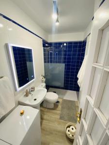 a bathroom with a white toilet and a blue tiled shower at EL JORADO in Tamaduste +17 photos