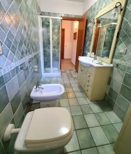 a bathroom with a white toilet and a sink at Mikey Appartamento con Terrazza in La Maddalena +30 photos