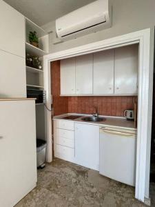 a white kitchen with a sink and a refrigerator at LOFT CASTILLO SANTA CLARA Torremolinos in Torremolinos