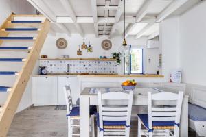 a kitchen with a table and chairs and a staircase at Chiarina's Spiti - Stylish & Peaceful in Old Town in Skopelos Town