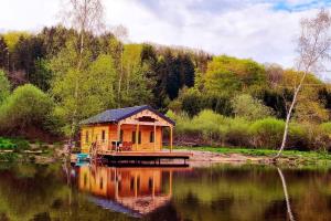 Cabaña de madera en un lago con muelle en Cabane pilotis sur étang, au lac de Chaumeçon en Saint-Martin-du-Puy