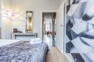 a bedroom with a bed and a geometric wall at Apartament Soleil III in Gdańsk