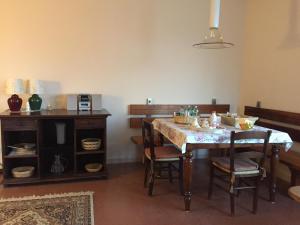 a dining room with a table with chairs and a microwave at LA CASA TRA GLI OLIVI in Sona