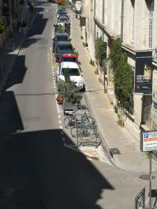 a street with parked cars and bikes parked on the sidewalk at Escale citadine au centre d'Avignon, climatisation, appartement de charme, spacieux et lumineux in Avignon