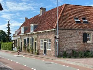 une maison en briques avec un toit rouge dans une rue dans l'établissement monumentaal huisje Bed & Meer, à Veere