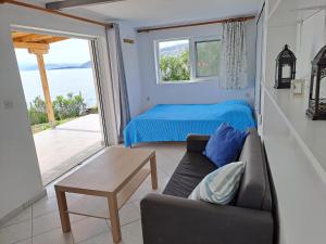 sala de estar con sofá, cama y ventana en Beach Studio Kotrona, en Achladi