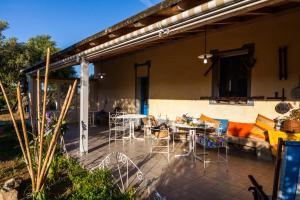 a patio with a couch and tables and chairs at The Old Farm Asfodeli - Adults Only in Sanalvò