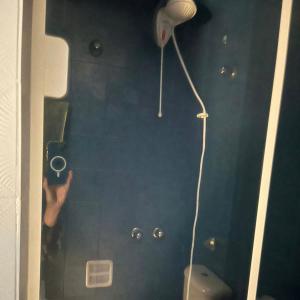 a person is holding a hair dryer in a bathroom at Espaço Azul in Curitiba