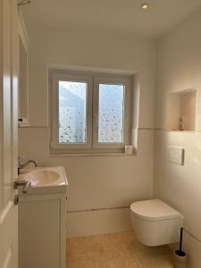 La salle de bains est pourvue de toilettes, d'un lavabo et d'une fenêtre. dans l'établissement Wittinghuus - Urlaub aan de Ostsee, à Timmendorfer Strand