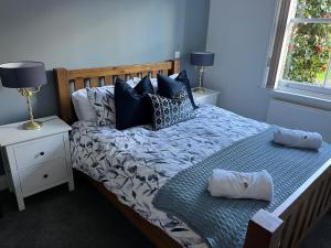 a blue bedroom with a bed with two pillows at The Snicket Apartment in Basingstoke