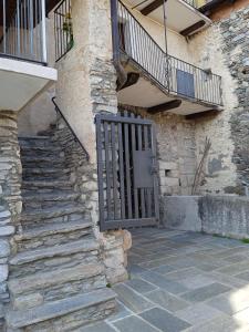 ein Steingebäude mit einem Tor und einer Treppe in der Unterkunft Casa Elisa apartment in Armeno