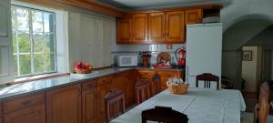 a kitchen with wooden cabinets and a white refrigerator at Quinta da Barbosa in Folgosinho