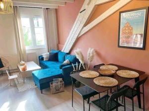 a living room with a blue couch and a table at Tres bel appartement le Concordance in Mulhouse