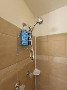 a shower with a bottle of water on a shower head at Lovely welcoming 3 bedroom house 