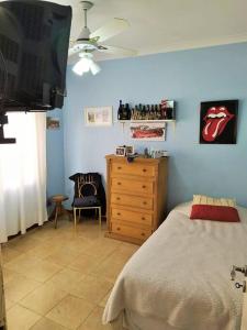 a bedroom with a bed and a dresser and a television at Casa Mercedes in Mercedes