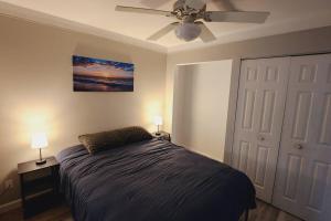 Schlafzimmer mit einem Bett und einem Deckenventilator in der Unterkunft Harbor Haven: Stay, Sail, Dine! 