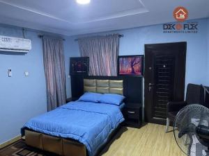 Dex & Flex Apartments في إيبادان: غرفة نوم بسرير وكرسي ومروحة