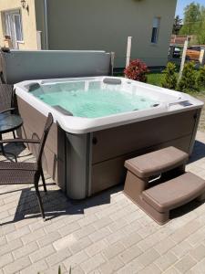 bañera de hidromasaje en un patio con silla en Konrad Apartman en Balatonmáriafürdő