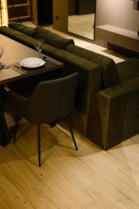 Luxury Apartments-Belochka في أوجهورود: غرفة معيشة مع أريكة خضراء وطاولة