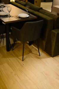 a dining room table with a chair and a couch at Luxury Apartments-Belochka in Uzhhorod