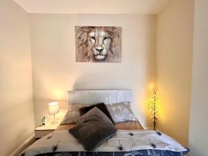 a bedroom with a bed with a painting of a lion at Relax dotcom in Manchester