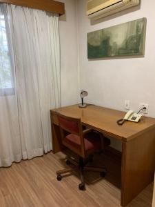 escritorio de madera con teléfono y silla en EXECUTIVE SUITE 106a VILA OLIMPIA, en São Paulo