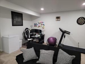 a living room with a couch and a gym at Cozy Peaceful B&B in Rosedale