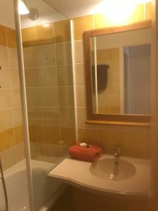 ein Badezimmer mit einem Waschbecken, einem Spiegel und einer Badewanne in der Unterkunft Appartement 4 pers1 chb Résidence du Lac vue sur les bois in Monflanquin