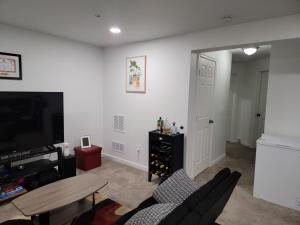 a living room with a tv and a table at Cozy Peaceful B&B in Rosedale