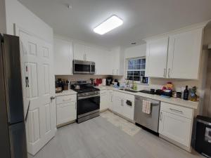 a kitchen with white cabinets and a stove top oven at Cozy Peaceful B&B in Rosedale