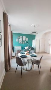 a living room with a table and chairs and a couch at Appartement T3 à deux pas du centre-ville in Vichy