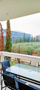 a table and chairs on a balcony with a view of a building at Filoxenia House Marousi -private parking- in Athens
